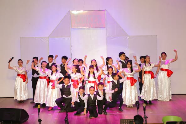 A group of children performing on stage AI-generated content may be incorrect.