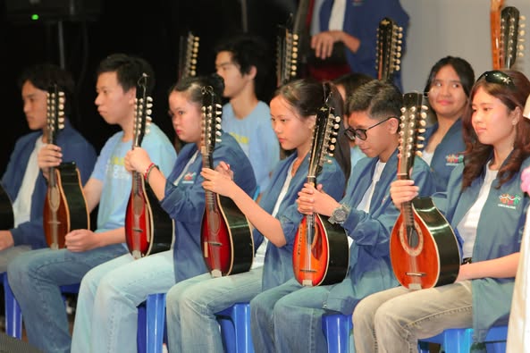 A group of people sitting on chairs holding musical instruments AI-generated content may be incorrect.